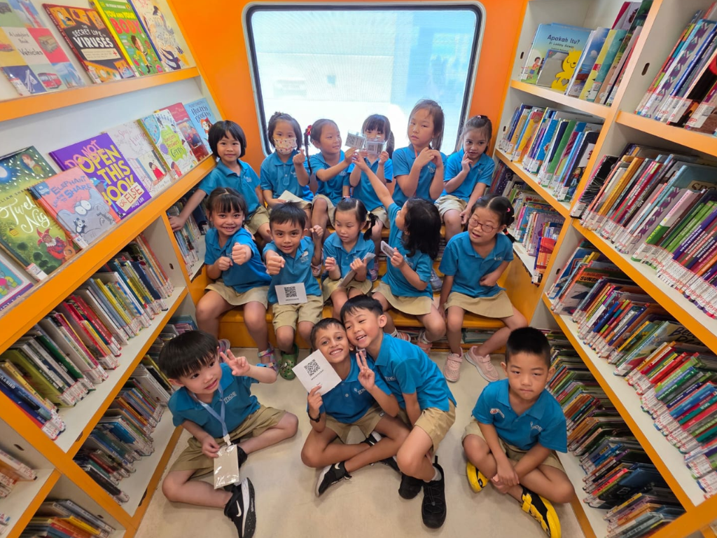 MOE Kindergarten children enjoy reading and exploring a variety of books inside the National Library Board's Molly Bus mobile library.